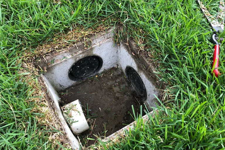In a green lawn install landscape drainage System in Houston, TX