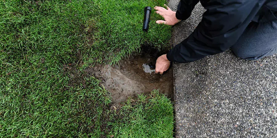 A Pearce Scapes team member repairing the sprinkler system